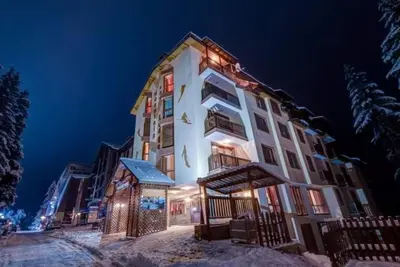 a large building with lights on it in the snow at Снежна приказка Пампорово в хотел Mountain Lodge ап 29 in Pamporovo