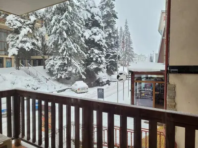 a balcony with a snow covered street with cars parked at Снежна приказка Пампорово в хотел Mountain Lodge ап 29 in Pamporovo