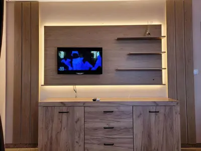 a entertainment center with a tv on a wall at Снежна приказка Пампорово в хотел Mountain Lodge ап 29 in Pamporovo