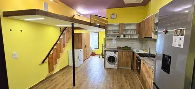 a kitchen with yellow walls and a washer and dryer at Tranquility Lodge, next to Paradise and metro station in Sofia