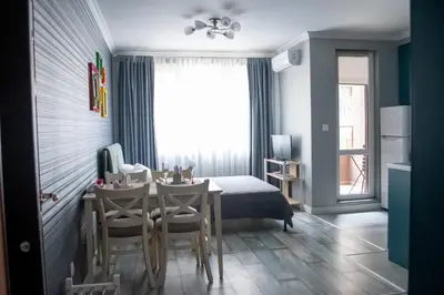 a bedroom with a table and chairs and a bed at HD Comfort Apartment in Sofia