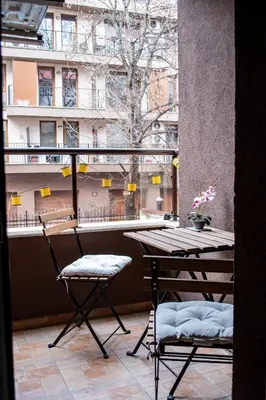 a balcony with a table and two chairs and a window at HD Comfort Apartment in Sofia