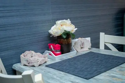 a table with a vase with white flowers on it at HD Comfort Apartment in Sofia
