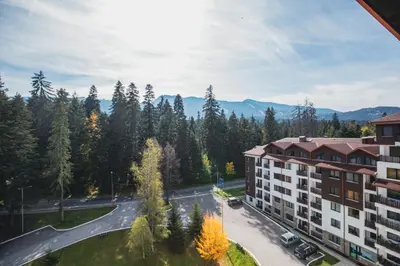 an aerial view of a building with trees and a street at Borovets Gardens Aparthotel Seasons Borovets PM in Borovets