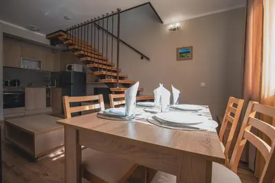 a kitchen and dining room with a wooden table at Borovets Gardens Aparthotel Seasons Borovets PM in Borovets