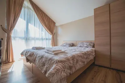 a bedroom with a bed with a large window at Borovets Gardens Aparthotel Seasons Borovets PM in Borovets