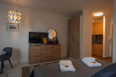 a bedroom with a bed and a dresser with a television at Borovets Gardens Aparthotel Seasons Borovets PM in Borovets
