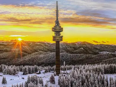 a view of a tower in the snow at sunset at Castle Inn Pamporovo in Pamporovo