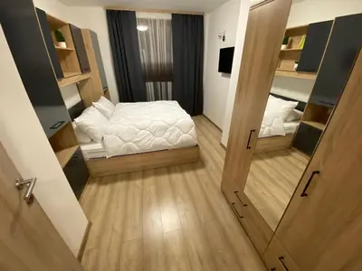 a small room with a bed and two open doors at Castle Inn Pamporovo in Pamporovo