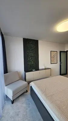 a bedroom with a bed and a chair and a window at Stylish and Modern 1bdrm apt free private parking in Sofia