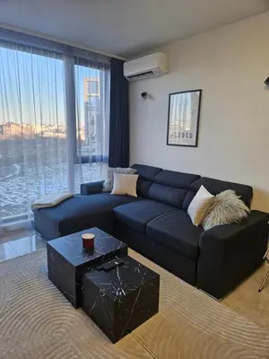 a living room with a blue couch and a table at Stylish and Modern 1bdrm apt free private parking in Sofia