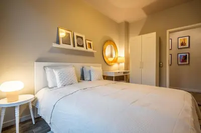 a bedroom with a large white bed and a table at Stylish 2 BDRM Apt at NDK in Sofia
