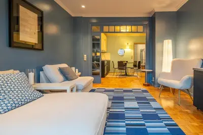 a bedroom with a bed and a living room at Stylish 2 BDRM Apt at NDK in Sofia