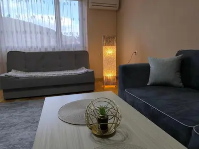 a living room with a couch and a table at Апартамент Котеви in Sandanski