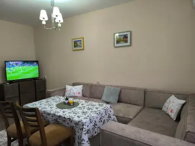 a living room with a couch and a table and a television at Апартамент Котеви in Sandanski