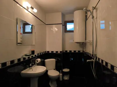 a bathroom with a white toilet and a sink at Апартамент Котеви in Sandanski