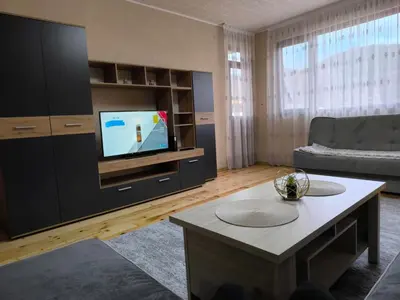 a living room with a couch and a tv at Апартамент Котеви in Sandanski