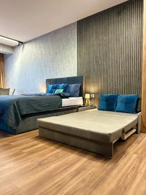 two beds with blue pillows in a bedroom at West Point Luxury studio in Plovdiv