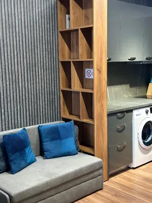 a living room with a couch and a washing machine at West Point Luxury studio in Plovdiv