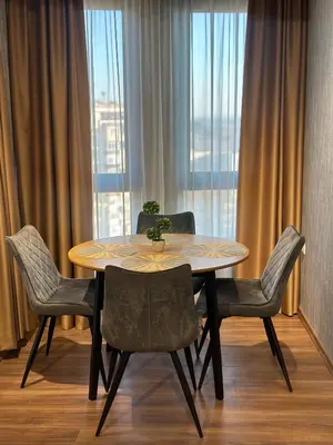 a dining room table and chairs with a large window at West Point Luxury studio in Plovdiv