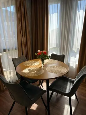 a table with chairs and a vase of flowers on it at West Point Luxury studio in Plovdiv