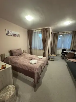 a bedroom with a bed and a table and chairs at Borovetz Gardens MVS Apart E28 in Borovets