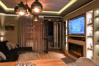 a living room with a tv and a couch and a fireplace at All Seasons Apartment in Sofia