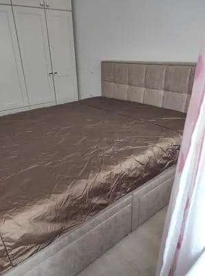 a bed in a room with a bed frame at Апартамент Сандански Център in Sandanski