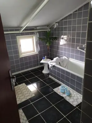 a blue tiled bathroom with a tub and a sink at Gologanova house in Kalofer