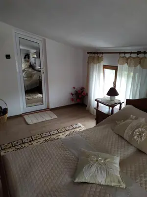 a bedroom with a large bed and a large mirror at Gologanova house in Kalofer