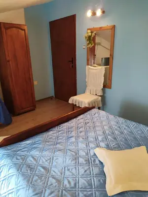 a bedroom with a bed and a mirror and a chair at Gologanova house in Kalofer