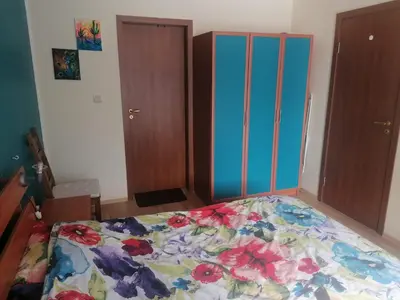 a bedroom with a bed with a floral bedspread at ИН Хоум Комфорт in Borovets