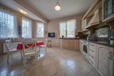 a kitchen with a table and a table and chairs at The Exquisite Residence in Zheleznitsa