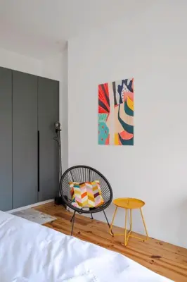 a room with a bed with a chair and a table at Luminous Central Retreat Spacious 2BD Apartment by Flat Mаnager in Sofia