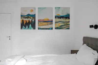 a bedroom with a bed with four paintings on the wall at Luminous Central Retreat Spacious 2BD Apartment by Flat Mаnager in Sofia