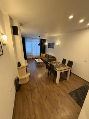 a living room with a table and chairs and a couch at From Sunrise to Sunset at Oak Residence Smolyan in Smolyan