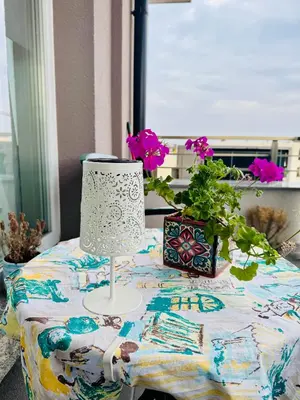 a table with a lamp and a potted plant on it at Cozy place for nights in Plovdiv