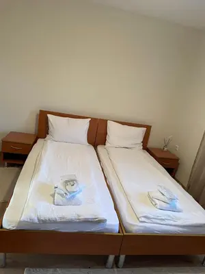 a bed with two pillows and towels on it at The New Inn in Bansko