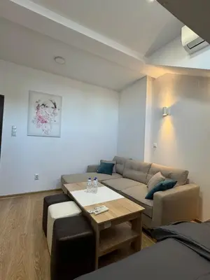 a living room with a couch and a table at Cozy High-Street Loft in Sofia's Best Central Location in Sofia
