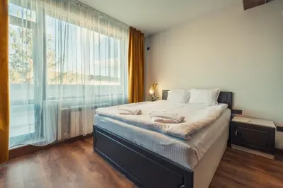 a bedroom with a large bed and a large window at Mirror Lake Studio in Samokov