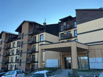 an apartment building with cars parked in front of it at At Marti in Bansko