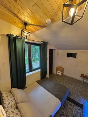 a bedroom with a large bed with green curtains at Quattro Malyovitsa- Мальовица in Govedartsi