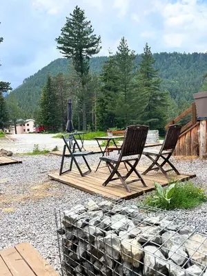 two chairs and a table on a wooden deck at Quattro Malyovitsa- Мальовица in Govedartsi