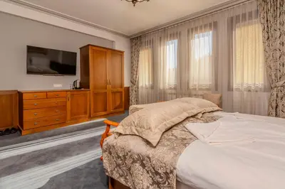 a bedroom with a bed and a dresser and a tv at Къща за гости Карлък in Smolyan