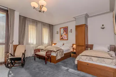 a bedroom with two beds and a chair at Къща за гости Карлък in Smolyan