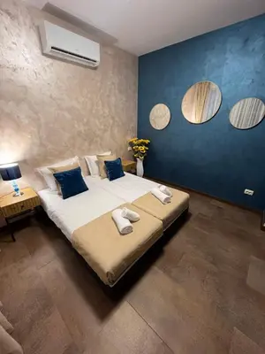a bedroom with a large bed and two mirrors at BoxRoom1 in Kyustendil
