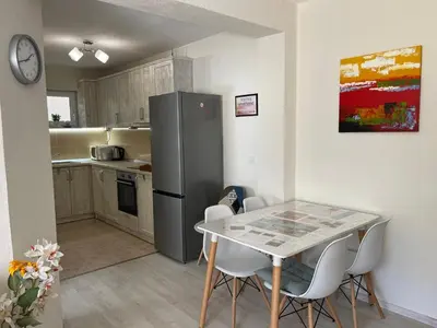 a kitchen with a table and a refrigerator at Positive Apartment in Petrich