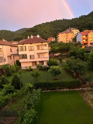 a rainbow in the sky over a city with a yard at Positive Apartment in Petrich