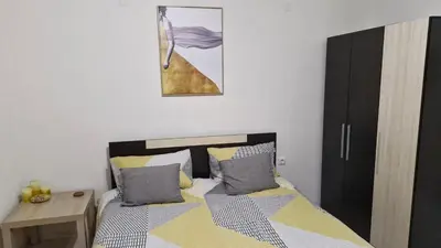 a bedroom with a bed and a table and a picture at Positive Apartment in Petrich