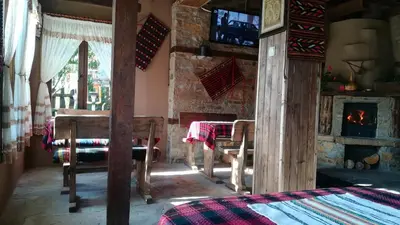 a living room with a table and a fireplace at Spa&Relax Скендерова Къща in Leshten